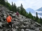 Seppe en Bobbie klimmen over de rotsen richting de waterval.