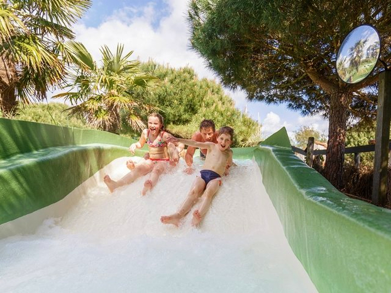 Kinderen spelen op de waterglijbaan bij het zwembad van het peutervriendelijke Center Parcs Port Zélande in Zeeland.