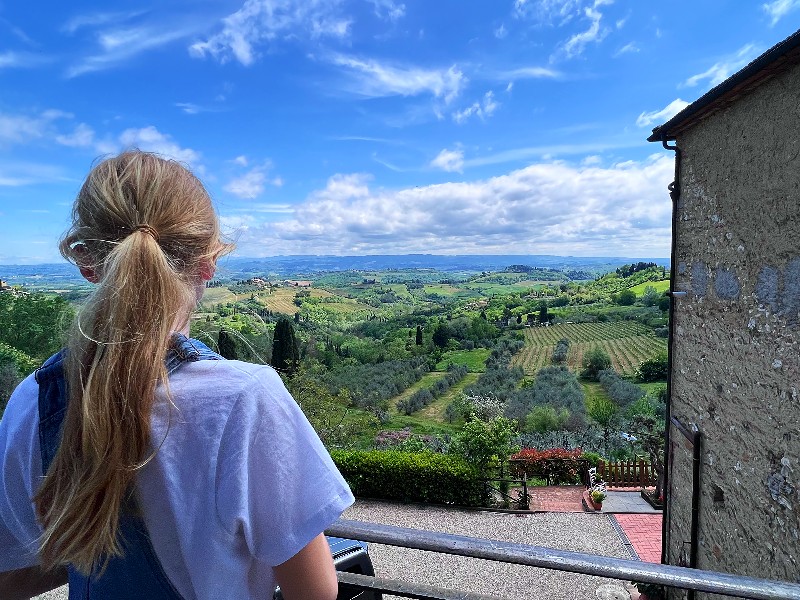Lara kijkt naar het uitzicht van Gimignano