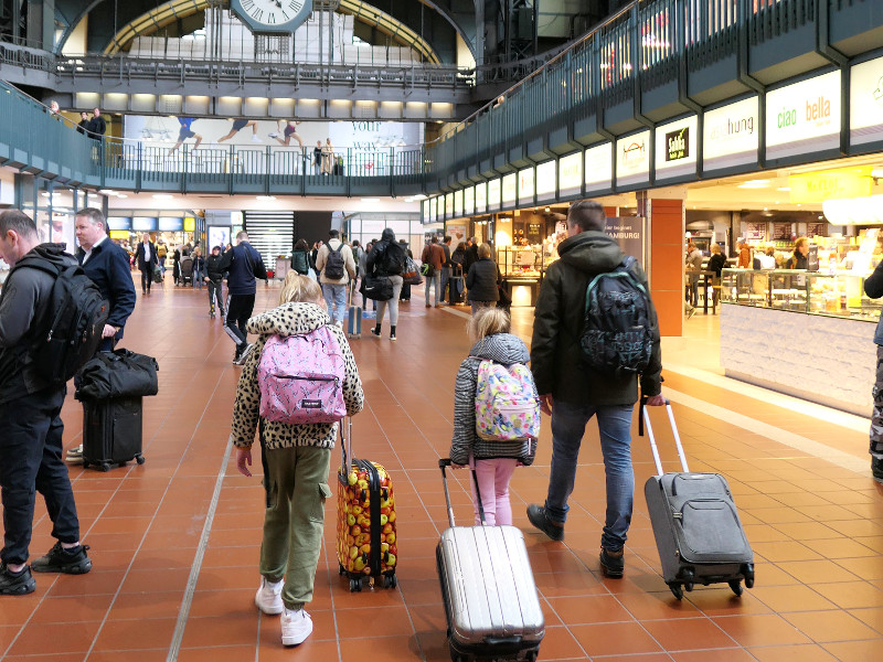 Wandelend met de koffer over het treinstation van Hamburg