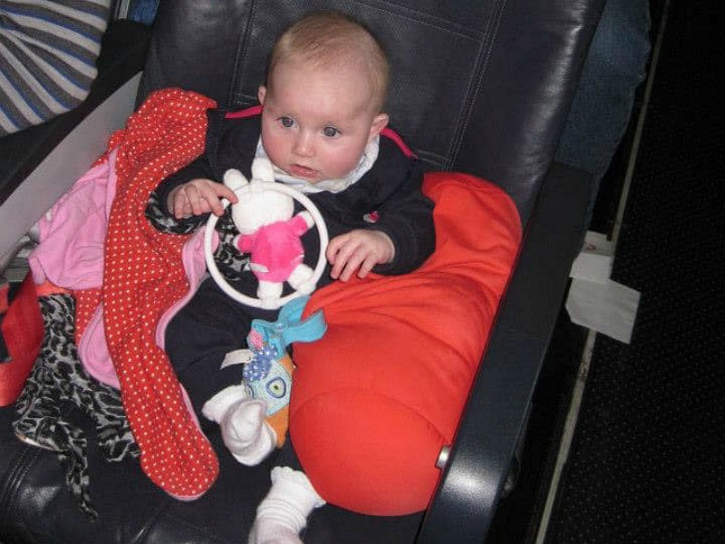 Baby in het vliegtuig tussen de kussens en kleding