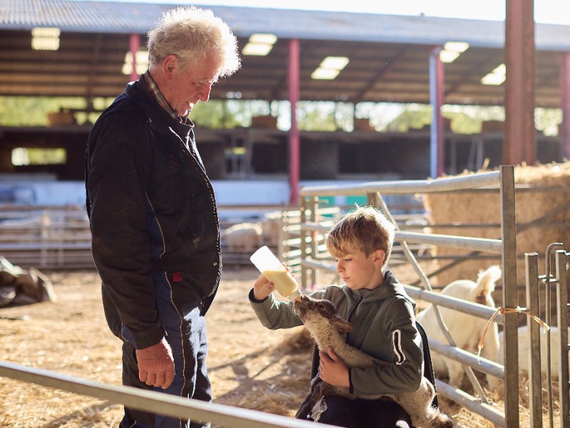 kind geeft fles aan geit