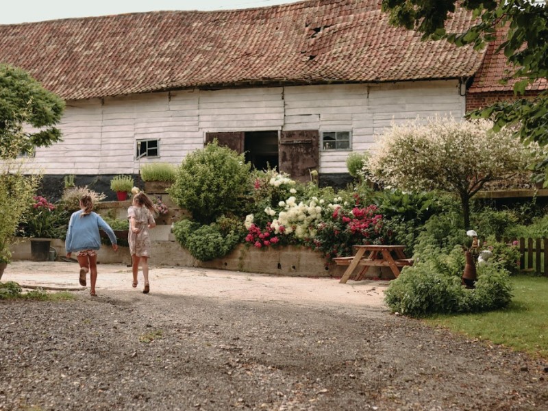 meisjes huppelen op erf van boerderij