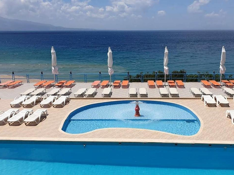 Het zwembad en strand bij de vakantiehuizen van Villa Skanderi in Sarandë in Albanië