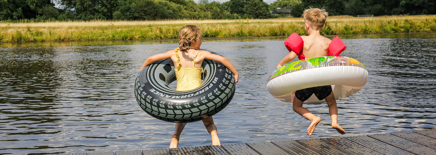 Kinderen springen de Vecht in op Natuurcamping de Roos in Overijssel