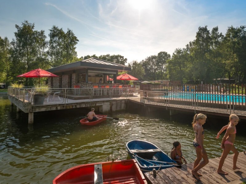 De poolbar met uitzicht op het zwembad en roeivijver