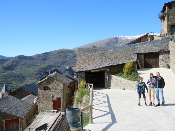 De parkeerplaats van Casa Bellera met dorp en bergen op de achtergrond