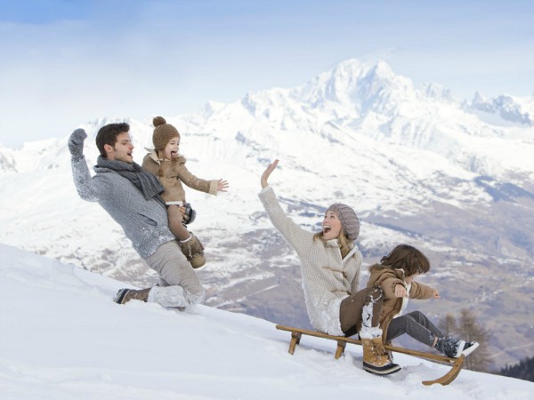 gezin op de slee in de sneeuw