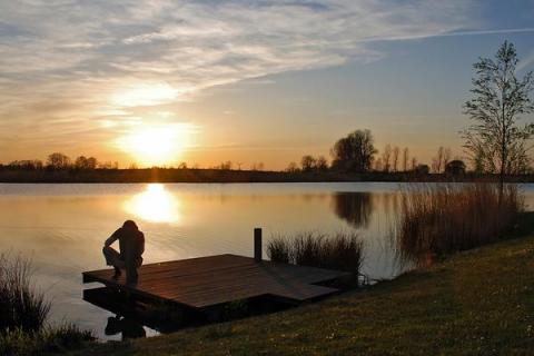 Van de zonsondergang genieten vanaf de steiger