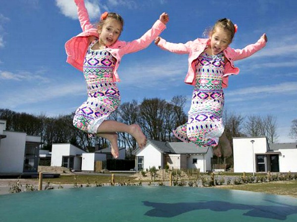 Tweeling op de airtrampoline op het vakantiepark