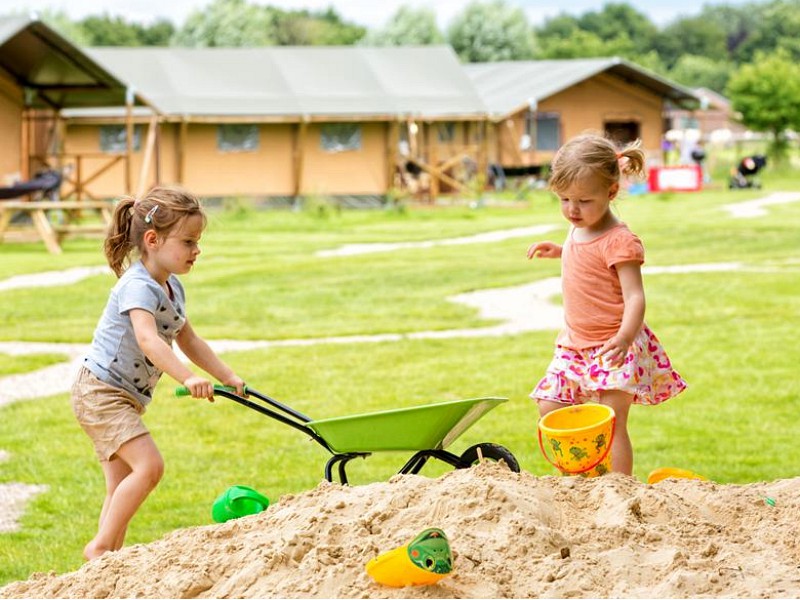 Kids spelen met zand op de FarmCamps boerderij