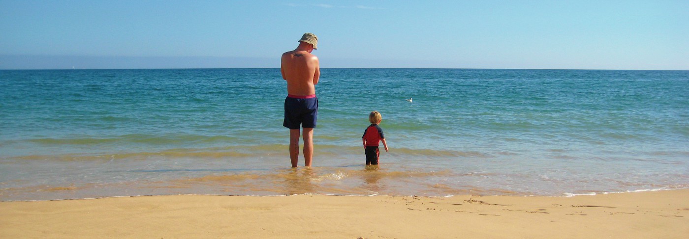 Vader met zoon in de zee van de Algarve