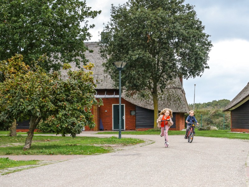 De kinderen van Elisabeth fietsen en steppen over het resort Hof van Saksen in Drenthe