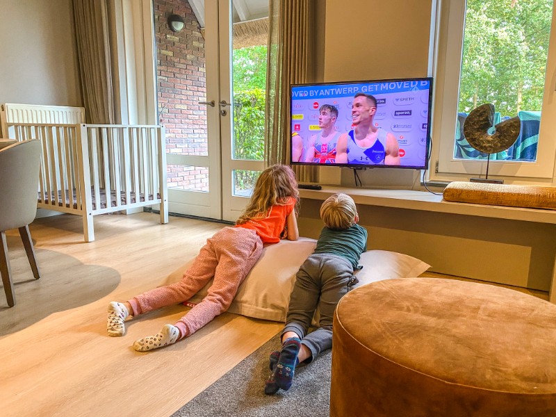De kinderen van Elisabeth kijken televisie in de vernieuwde kinderboerderij op resort Hof van Saksen