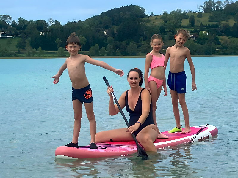 Ellen en haar kinderen op een sup-board in het meer Clairvaux bij camping le Foylan
