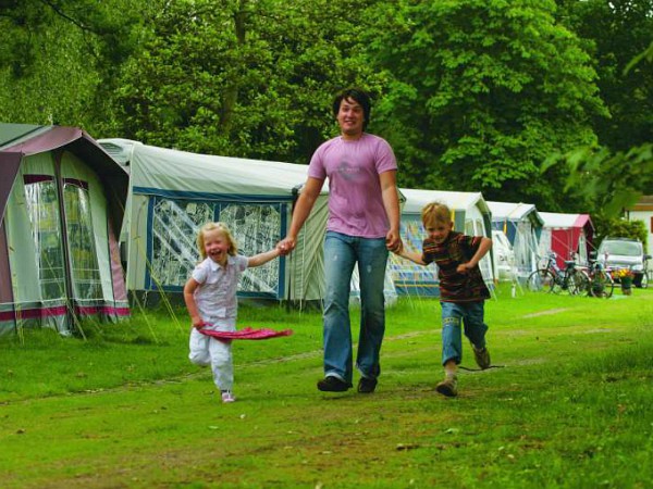 Vader met kinderen wandelen over de camping