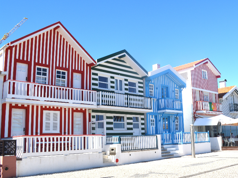 Vrolijk gekleurde strandhuizen langs het strand bij het plaatsje Aveiro in Noord-Portugal.