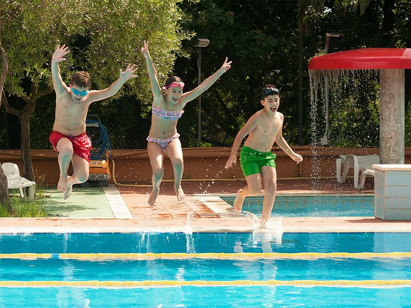Kids springen in het zwembad op een camping vlakbij Rome