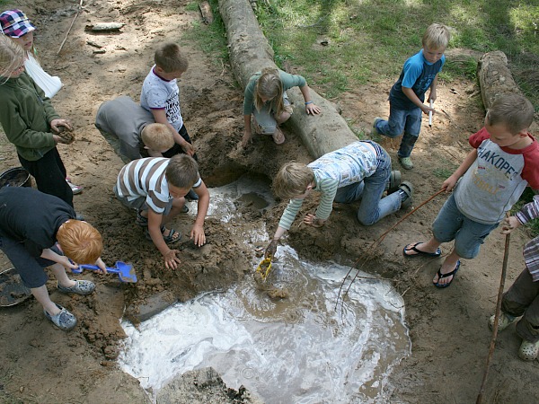 Jonge kinderen knoeien lekker met water en modder op de peutervriendelijke natuurcamping Lemeler Esch in Overijssel.