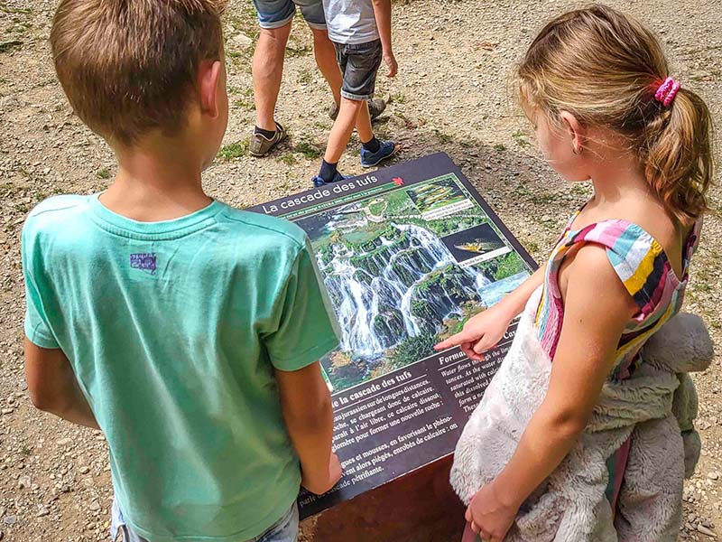 De kinderen bekijken hoe de Cascade des Tufs eruitziet als er wel water is