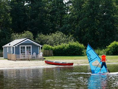 vakantiehuisje aan het water met surfer