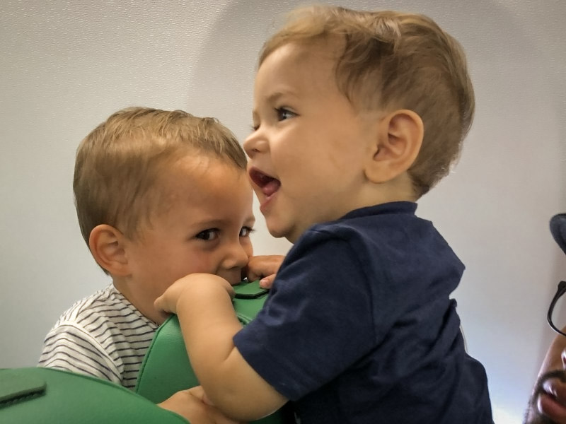 Peuters spelen in het vliegtuig over de stoelen