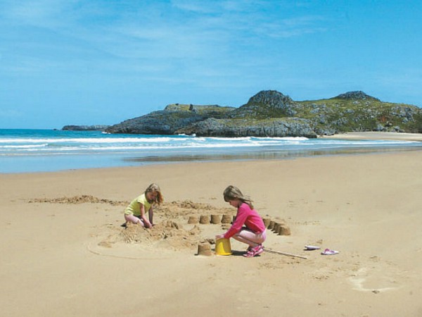 Kinderen maken een zandkasteel op het strand