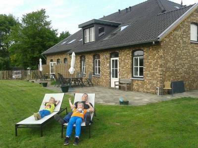 Onze kinderen poseren voor de vakantiewoningen van Herlaeve