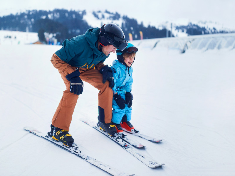 Vader en zoon op de piste, high five