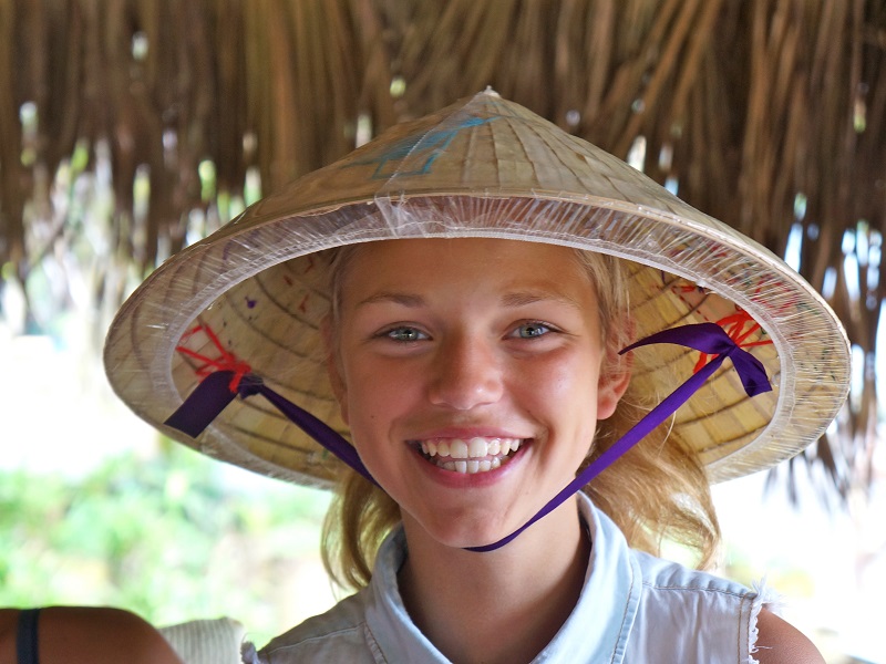 Blond meisje met Aziatische hoed