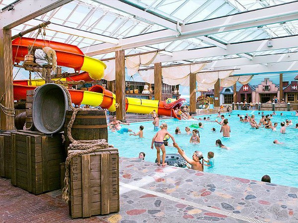 Kinderen en glijbaan in het binnenbad van Roompot Zeeduin