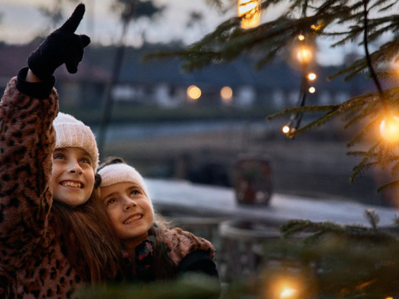 Meisjes bij de kerstboom in het safari resort.