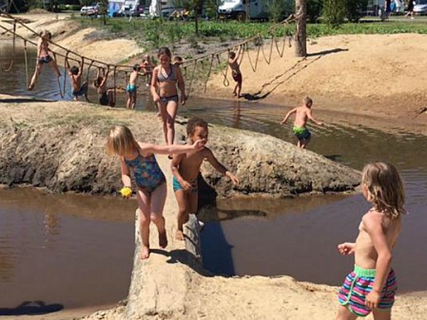 Kinderen op boomstam of touwbrug over water bij vakantiepark Sallandshoeve