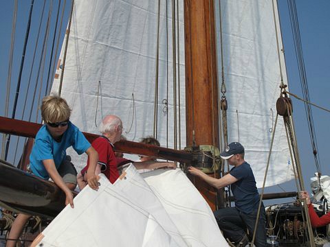 De kinderen helpen met het hijsen van de zeilen