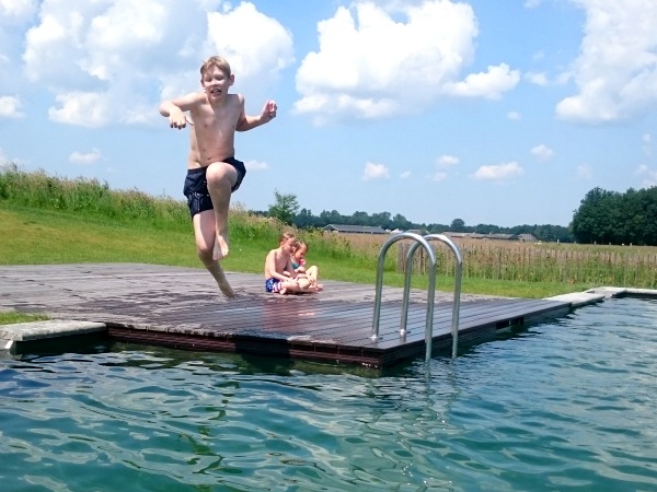 Zeb springt in het natuurlijke zwembad van Landal Orveltermarke