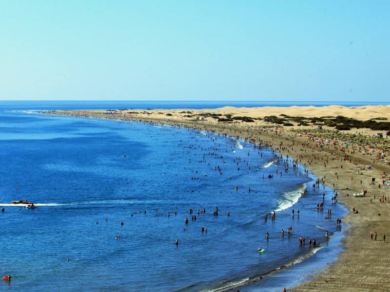 Het strand van Playa del Ingles met daarachter de duinen van Maspalomas
