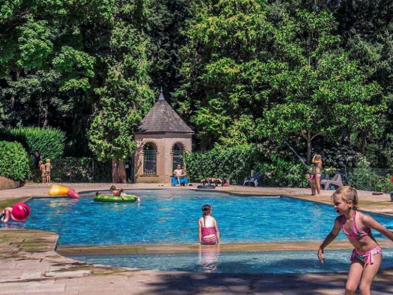 Kinderen spelen bij het zwembad van camping le Chateau de Montrouant