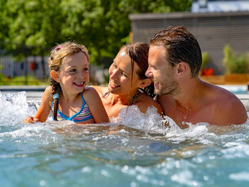 Een gezin geniet van het zwembad op camping Sandaya Paris Maisons Lafitte.