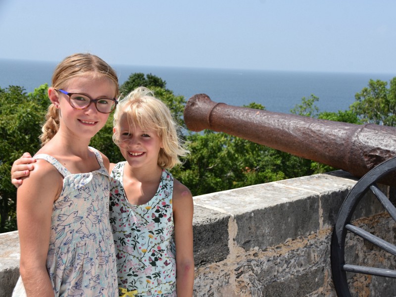 Kids in Mexico bij uitzicht op zee en bij een kanon