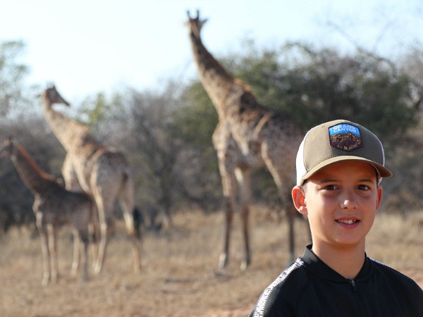 Jongen in Zuid Afrika voor de giraffen