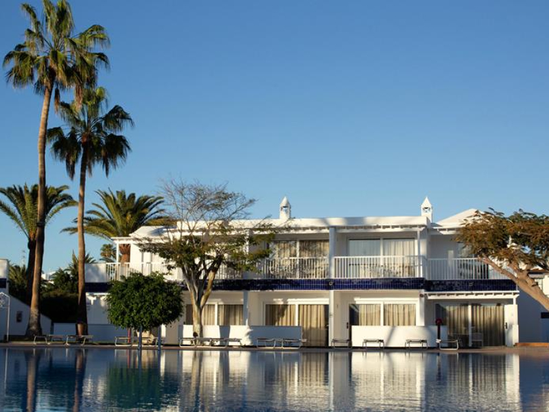 Uitzicht op appartementen aan het zwembad bij hotel Barcarola Club op Lanzarote in Spanje