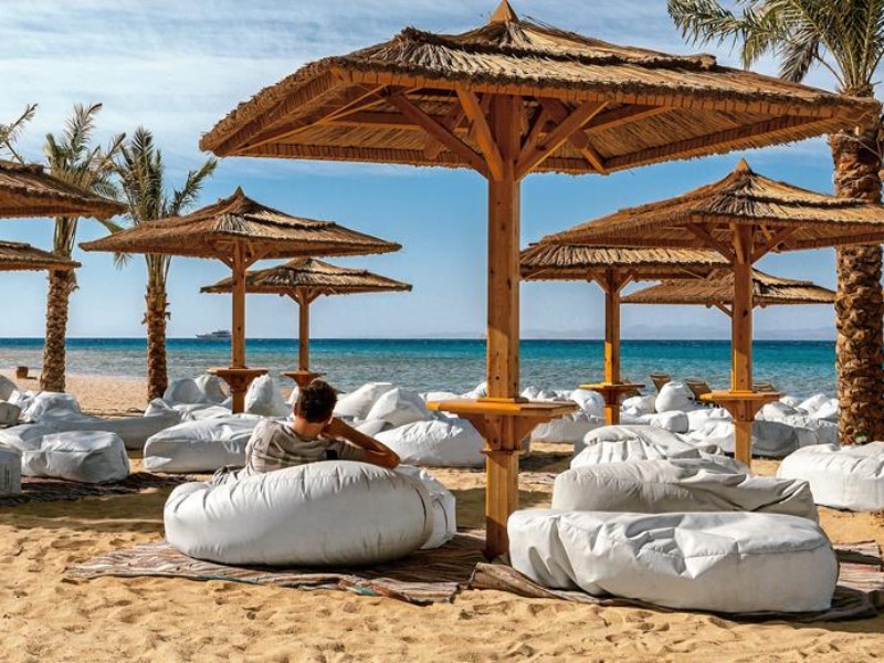 man op strand onder parasol