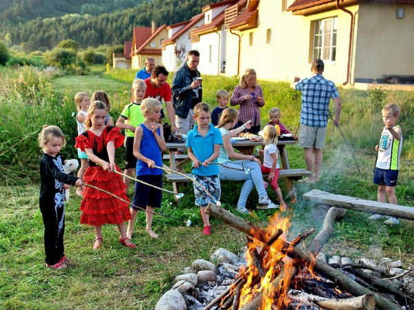 Kinderen roosteren marshmallows bij het kampvuur