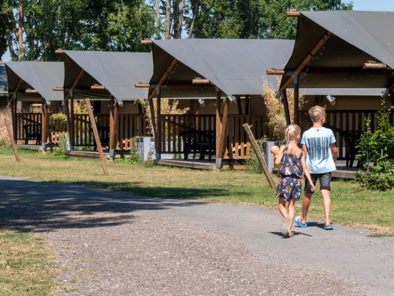 Kinderen wandelen langs de safaritenten op camping de Tolbrug