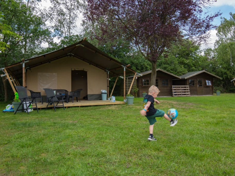 Kind voetbalt op het tentenvelt op camping Leef! in Limburg