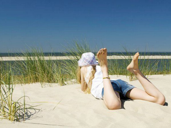 liggend in de duinen genieten van het uitzicht op zee