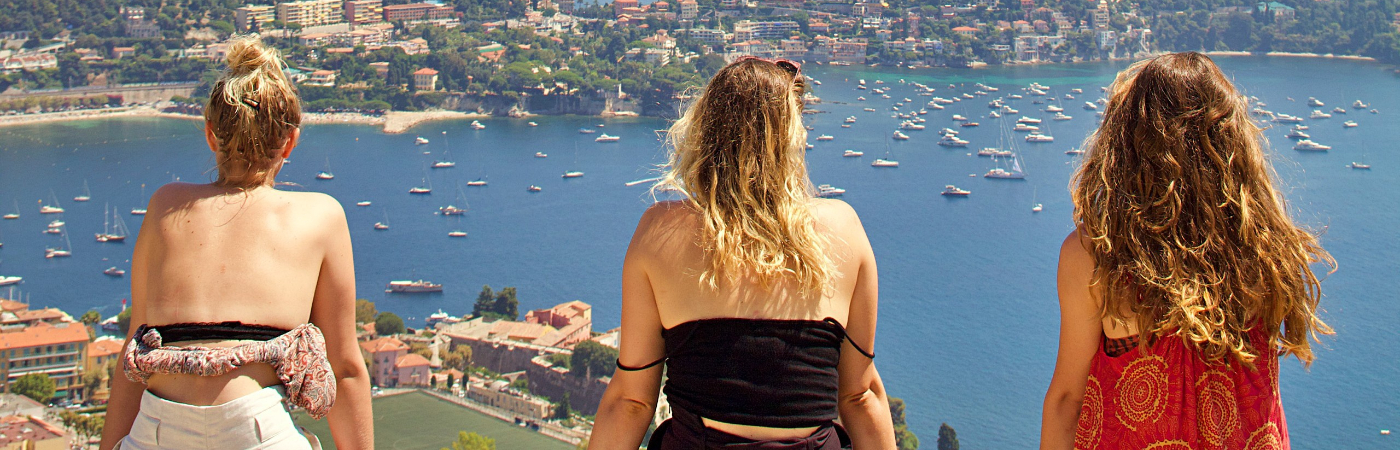 Vriendinnen kijken uit over een baai tijdens hun vakantie