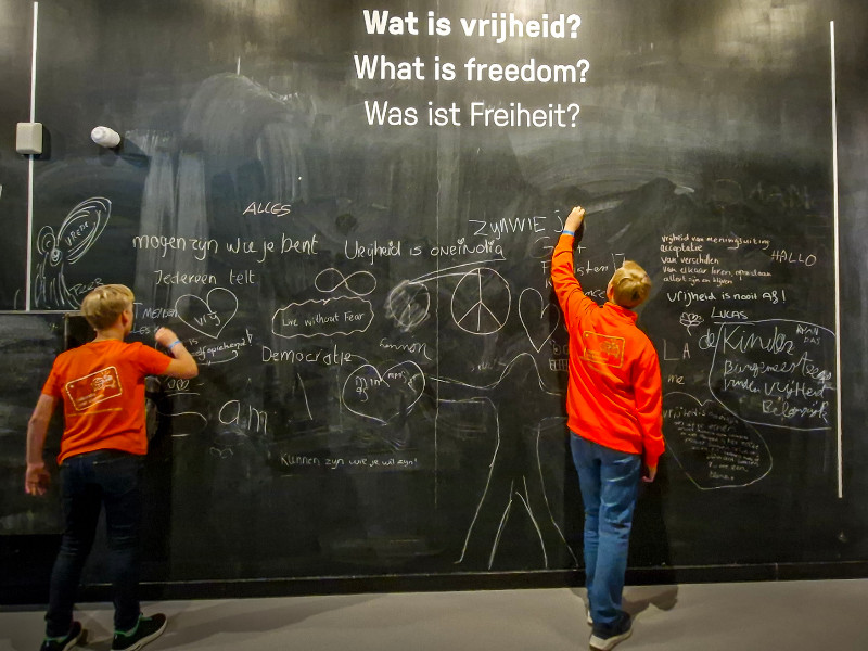 De kinderen schrijven op het bord wat vrijheid voor hun betekend in het Vrijheidsmuseum