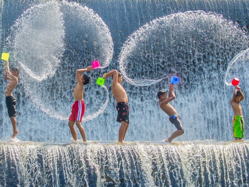 Spelende kinderen in een waterval in Bali