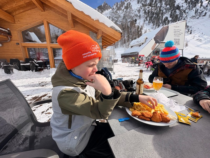 Seppe eet een frietje als lunch op de piste